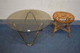 A CIRCULAR SMOKED GLASS TOP COFFEE TABLE on a shaped tubular brassed base, diameter 76cm x height