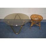 A CIRCULAR SMOKED GLASS TOP COFFEE TABLE on a shaped tubular brassed base, diameter 76cm x height