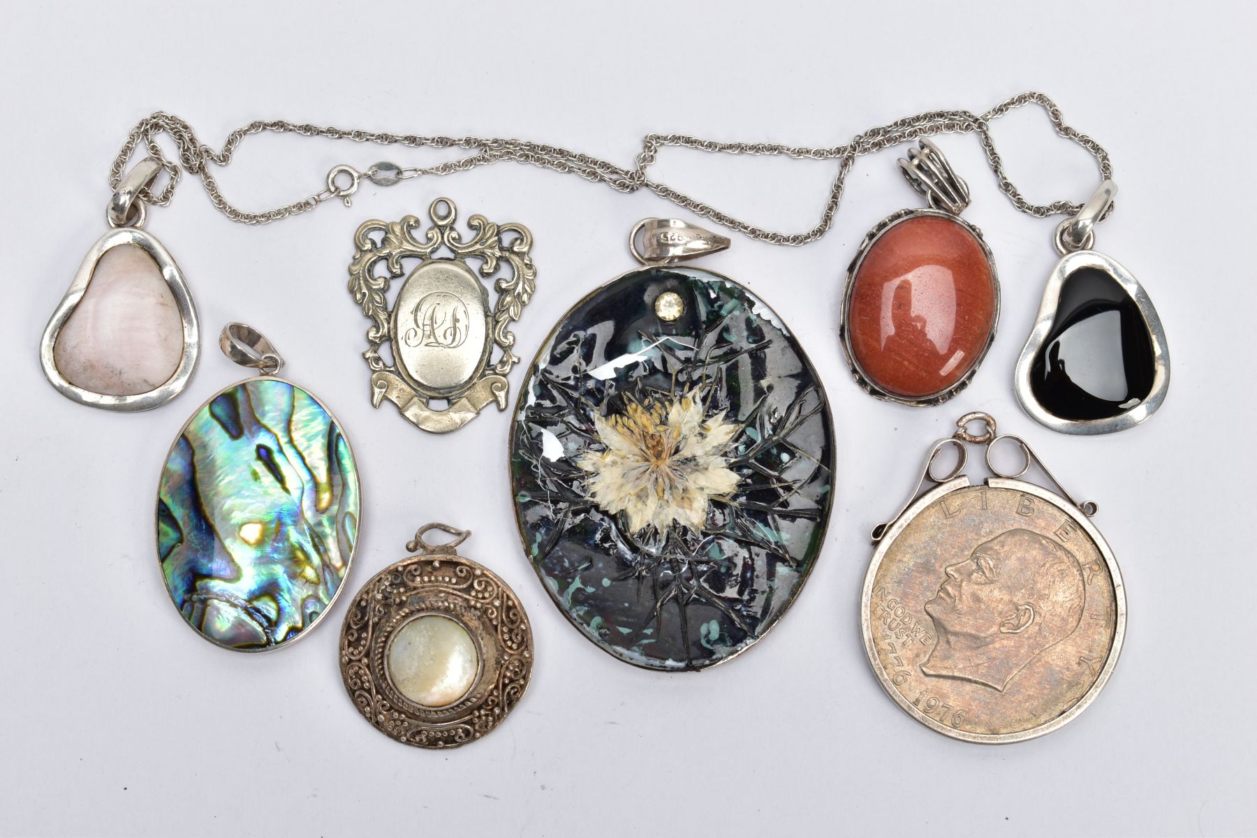 A SELECTION OF PENDANTS, to include an oval pendant with dyed sponge coral and abalone shell panels,