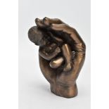 A MODERN SCULPTURE OF A BABY IN HAND (signed Tupton)