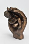 A MODERN SCULPTURE OF A BABY IN HAND (signed Tupton)