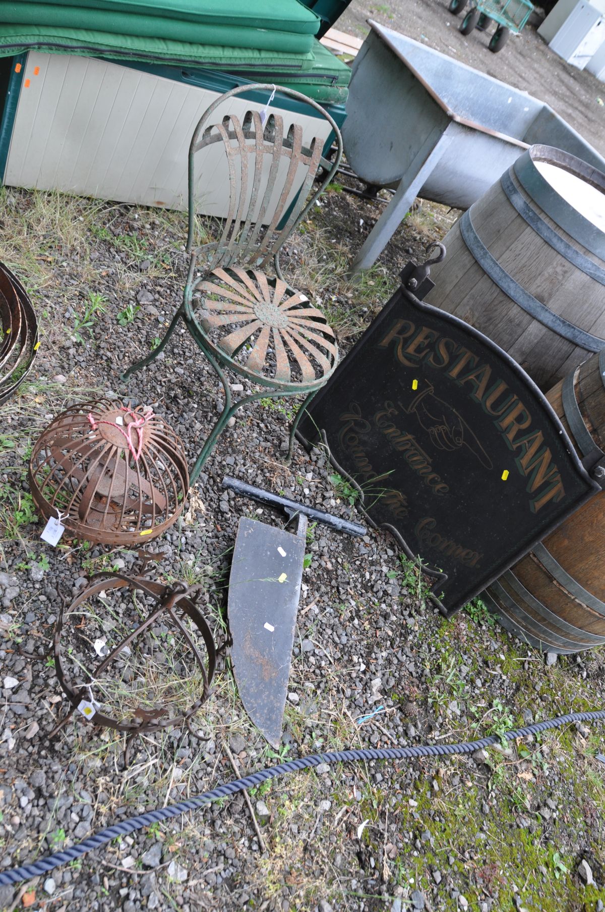 A METAL HANGING RESTAURANT SIGN width 72cm x height 72cm, a peat cutter, a French metal Bistro chair