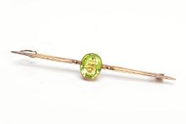 A PERIDOT BAR BROOCH, a single stone oval peridot miligrain set measuring approximately 10.0mm x 8.