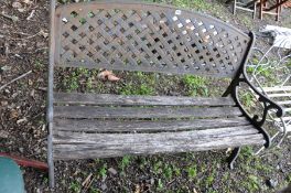 A GARDEN BENCH with pierced steel back , scrolled cast iron end and distressed slatted wood seat,