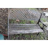 A GARDEN BENCH with pierced steel back , scrolled cast iron end and distressed slatted wood seat,