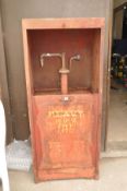 A LARGE VINTAGE METAL FUEL/OIL DISPENSER with sliding drop down door concealing a crank handle