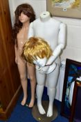 TWO PLASTIC CHILD SIZE MANNEQUINS ON STANDS, one in white with jointed parts, no head, the other a