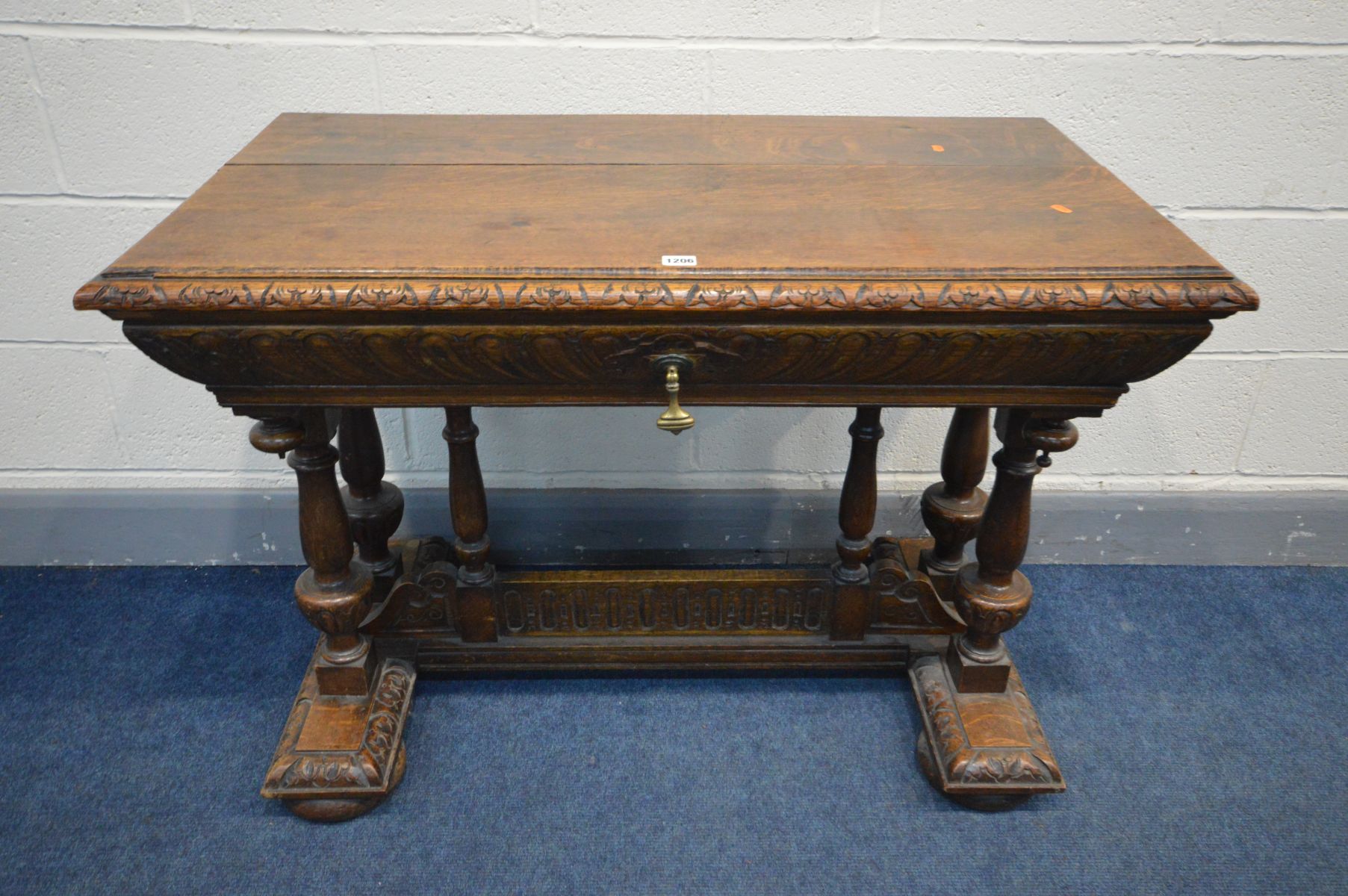 A 19TH CENTURY CARVED OAK CENTRE TABLE, rectangular top above a tapered frieze containing a long