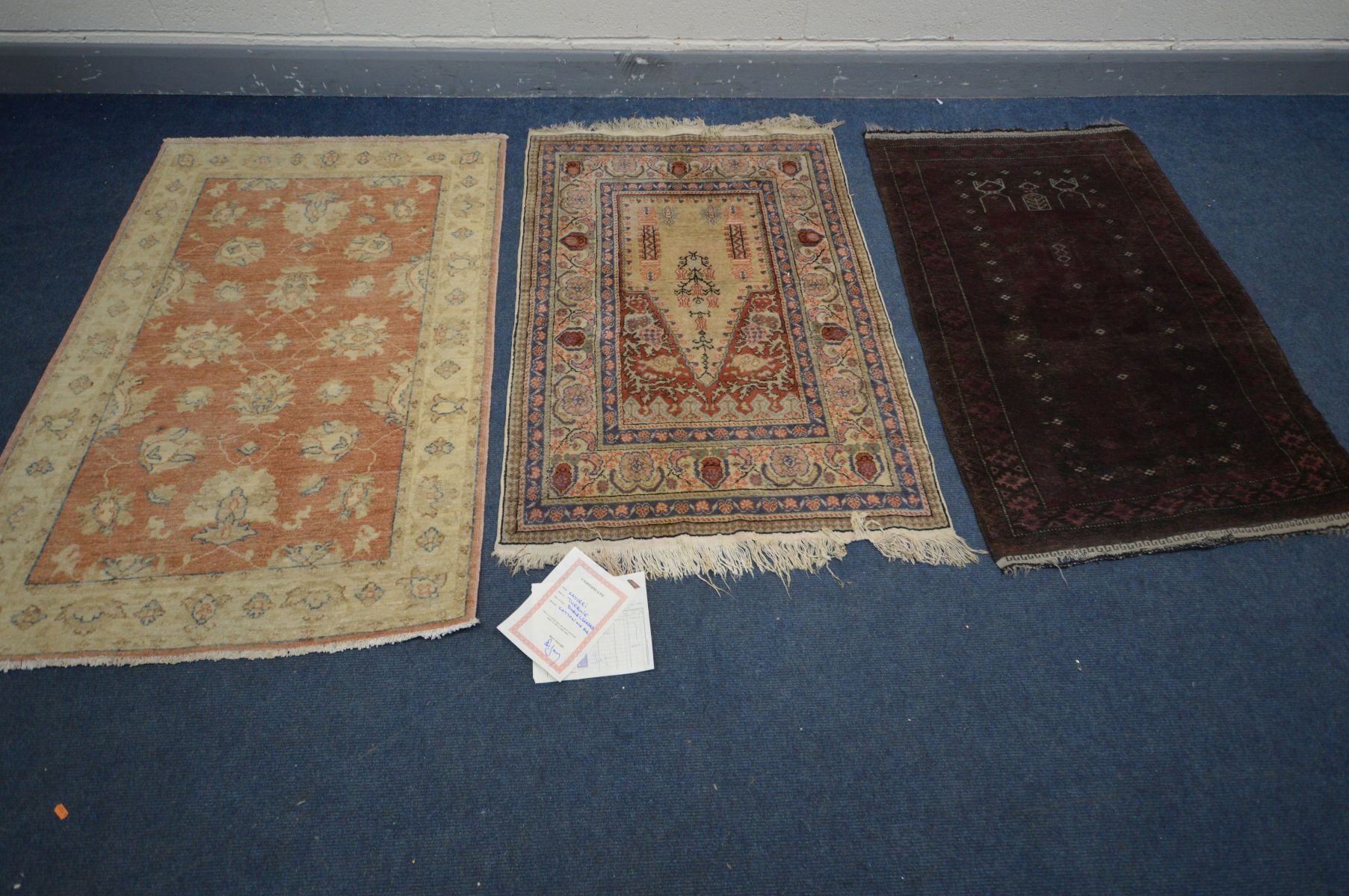 A SILK AND COTTON KAYSERI RUG, 137cm x 92cm, a similar red rug, and another rug (3)