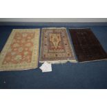 A SILK AND COTTON KAYSERI RUG, 137cm x 92cm, a similar red rug, and another rug (3)