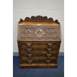 AN EARLY 20TH CENTURY OAK BUREAU, carved with scrolls, foliage and masks, gallery top, fall front