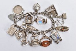 A CHARM BRACELET, the curb link bracelet suspending seventeen charms, to include a hinged shell