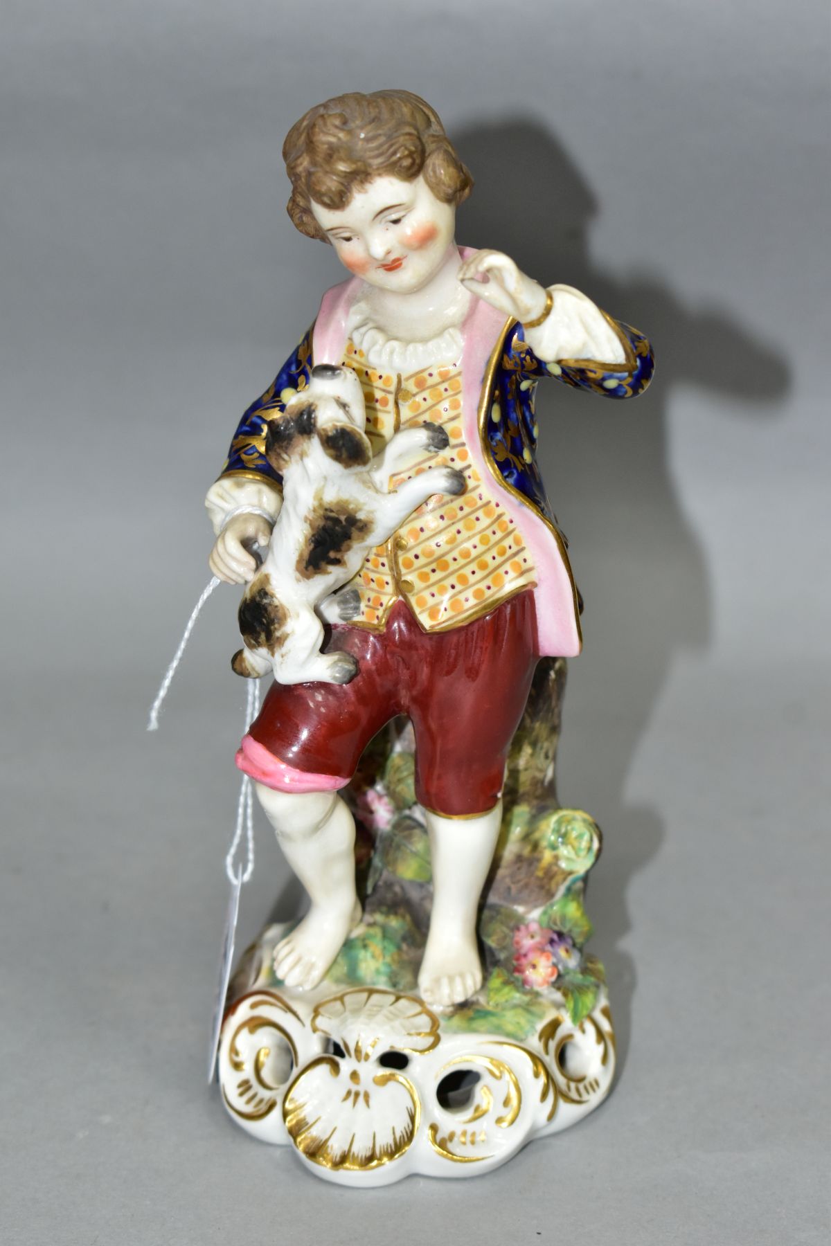 A STEVENSON & HANCOCK DERBY PORCELAIN FIGURE OF A BOY, modelled with a terrier standing on his knee,