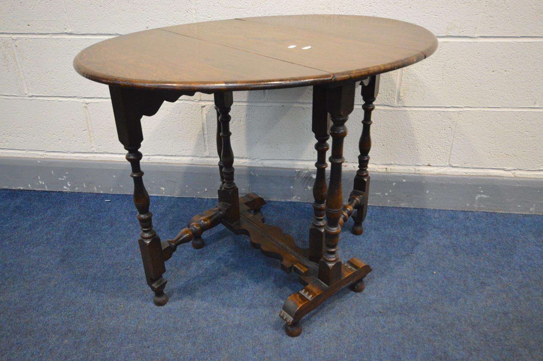 A MID TO LATE 20TH CENTURY OVAL OAK SUTHERLAND TABLE, with turned, bulbous and block supports,