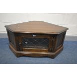 A DARK OAK JAYCEE CORNER TV CABINET, with a lead glazed door enclosing two shelves, width 103cm x