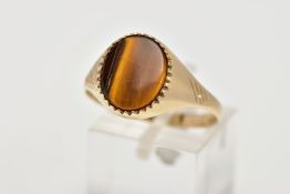 A 9CT GOLD TIGERS EYE SIGNET RING, a central oval tigers eye panel to the tapered band with diagonal