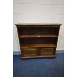 A REPRODUCTION OAK BOOKCASE, two open shelves above a double sliding door lunette section, on