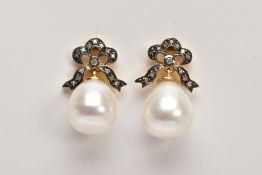 A PAIR OF YELLOW METAL, CULTURED PEARL AND DIAMOND DROP EARRINGS, each designed with bow shaped