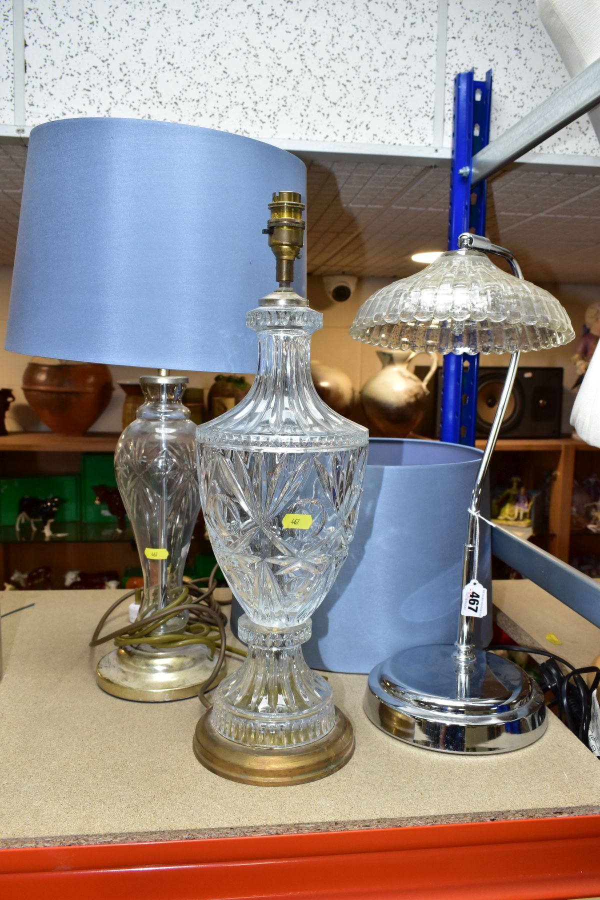 THREE ELECTRIC LAMPS, comprising a cut glass urn shaped table lamp with blue shade, height