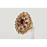 A 9CT GOLD GARNET DRESS RING, of a large openwork marquise shape, set with circular cut garnets,