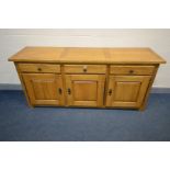 A MODERN SOLID GOLDEN OAK SIDEBOARD, three drawers above three cupboard doors, width 201cm x depth