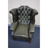 A GREEN LEATHER BUTTON BACK WINGBACK CHAIR on cabriole legs, width 90cm x depth 87cm x height