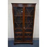 A GEORGIAN MAHOGANY TWO DOOR BOOKCASE, astragal glazing joined by inlaid partitions, enclosing