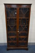 A GEORGIAN MAHOGANY TWO DOOR BOOKCASE, astragal glazing joined by inlaid partitions, enclosing