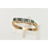 A GOLD-PLATED EMERALD AND CUBIC ZIRCONIA HALF ETERNITY RING, designed with a row of claw set,