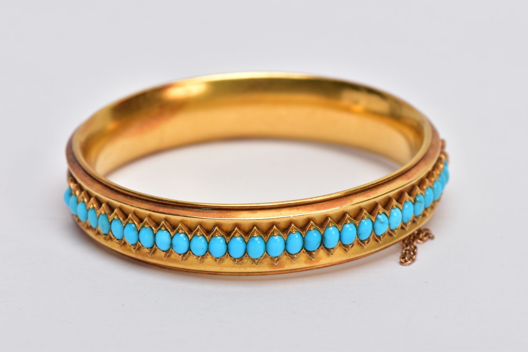 A LATE VICTORIAN TURQUOISE HINGED BANGLE, of slight concave design, the back half with central