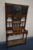 AN EARLY 20TH CENTURY OAK HALL STAND, with later tin panels flanking a bevelled edge mirror above