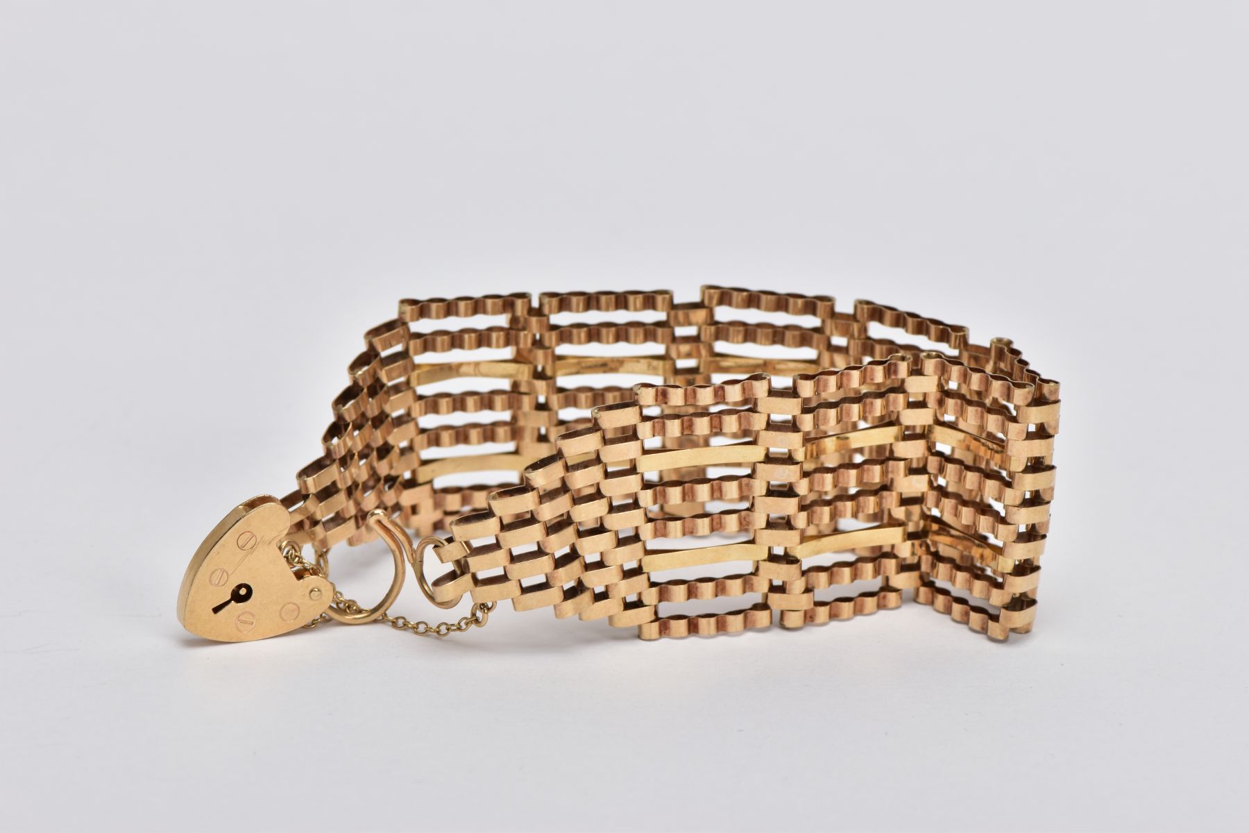 A 9CT GOLD WIDE GATE BRACELET, the gate bracelet with graduated terminals to the heart padlock clasp - Image 2 of 3