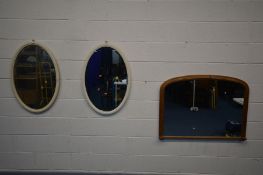 A PINE OVERMANTEL MIRROR, 102cm x 76cm and a pair of painted oval bevelled edge wall mirrors (3)