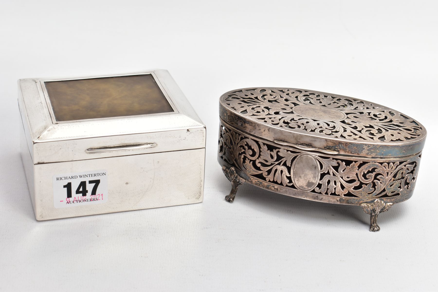 A GEORGE V SILVER LINED, SQUARE CIGARETTE BOX AND A PIERCED OVAL VANITY BOX, engine turned design