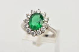 A 9CT WHITE GOLD CLUSTER RING, centring on an oval cut green stone assessed as paste, within a