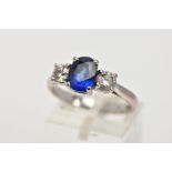 AN 18CT WHITE GOLD SAPPHIRE AND DIAMOND RING, designed with a four-claw set, oval cut blue sapphire,