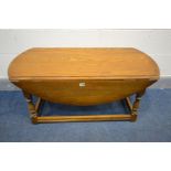 A LOW OAK OVAL TOP DROP LEAF COFFEE TABLE, length 107cm x open depth 96cm x closed length 53cm x