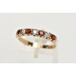 A 9CT GOLD GARNET AND CUBIC ZIRCONIA HALF ETERNITY RING, designed with a row of four circular cut