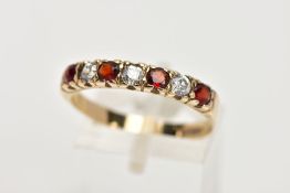 A 9CT GOLD GARNET AND CUBIC ZIRCONIA HALF ETERNITY RING, designed with a row of four circular cut
