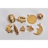 NINE 9CT GOLD CHARMS, to include a barrel, a hinged caravan, a pram and a telephone, all with 9ct