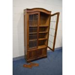AN EARLY 20TH CENTURY OAK DOUBLE DOOR BOOKCASE, the lead glazed doors enclosing three adjustable