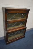 AN EARLY 20TH CENTURY OAK THREE SECTION BOOKCASE, lead glazed fall front doors and later internal