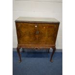 A REPRODUCTION BURR WALNUT TWO DOOR COCKTAIL CABINET, with a fitted interior, on cabriole legs,