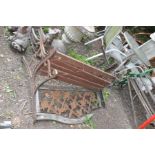 A DISTRESSED CAST IRON GARDEN BENCH with pierced metal back panel and wooden slatted seat 122cm
