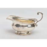 A GEORGE V SILVER SAUCE BOAT, plain polished body, wavy detailed rim, scroll and leaf detailed