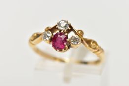 A YELLOW METAL RUBY AND DIAMOND DRESS RING, designed with a cushion cut ruby, flanked with old cut