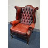 A BURGUNDY LEATHER BUTTONED WING BACK ARMCHAIR (condition - armrests worn, cracked and one rip,
