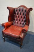 A BURGUNDY LEATHER BUTTONED WING BACK ARMCHAIR (condition - armrests worn, cracked and one rip,