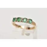 A 9CT GOLD EMERALD AND DIAMOND HALF ETERNITY RING, designed with a row of four claw set oval cut