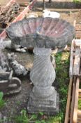 A LARGE COMPOSITE BIRDBATH with shell shaped top 52cm in diameter on a twisted baluster base with